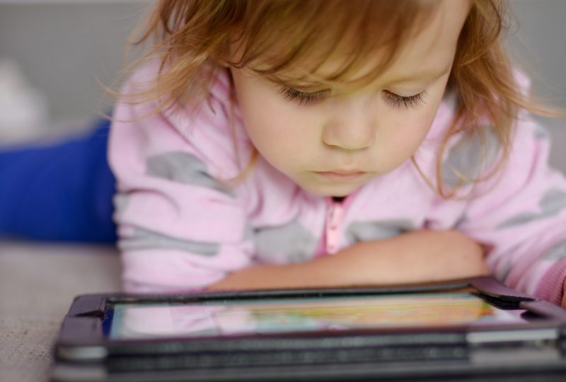 Cute toddler girl using tablet pc
