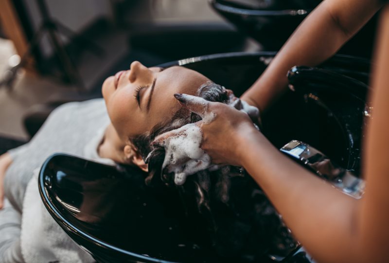 Belle jeune femme se faisant laver les cheveux. Concept de coiffure dans un salon de coiffure.